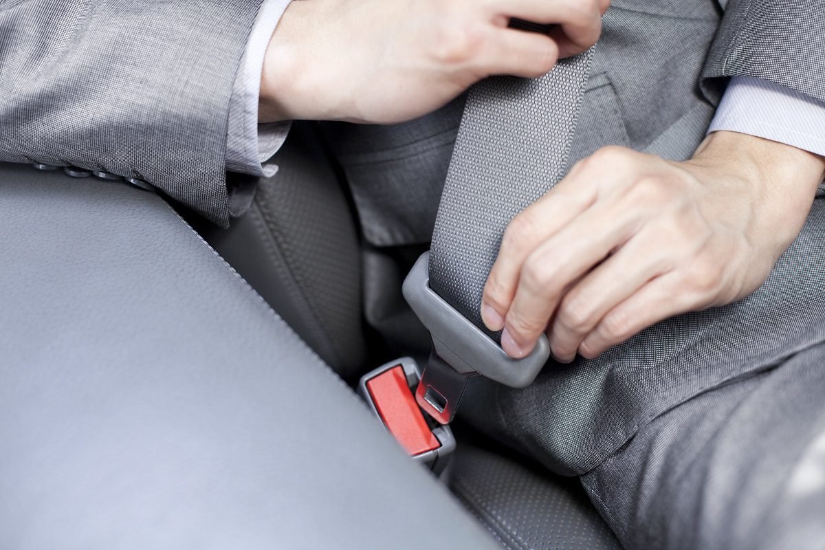 Chinese businessman fastening the seat belt