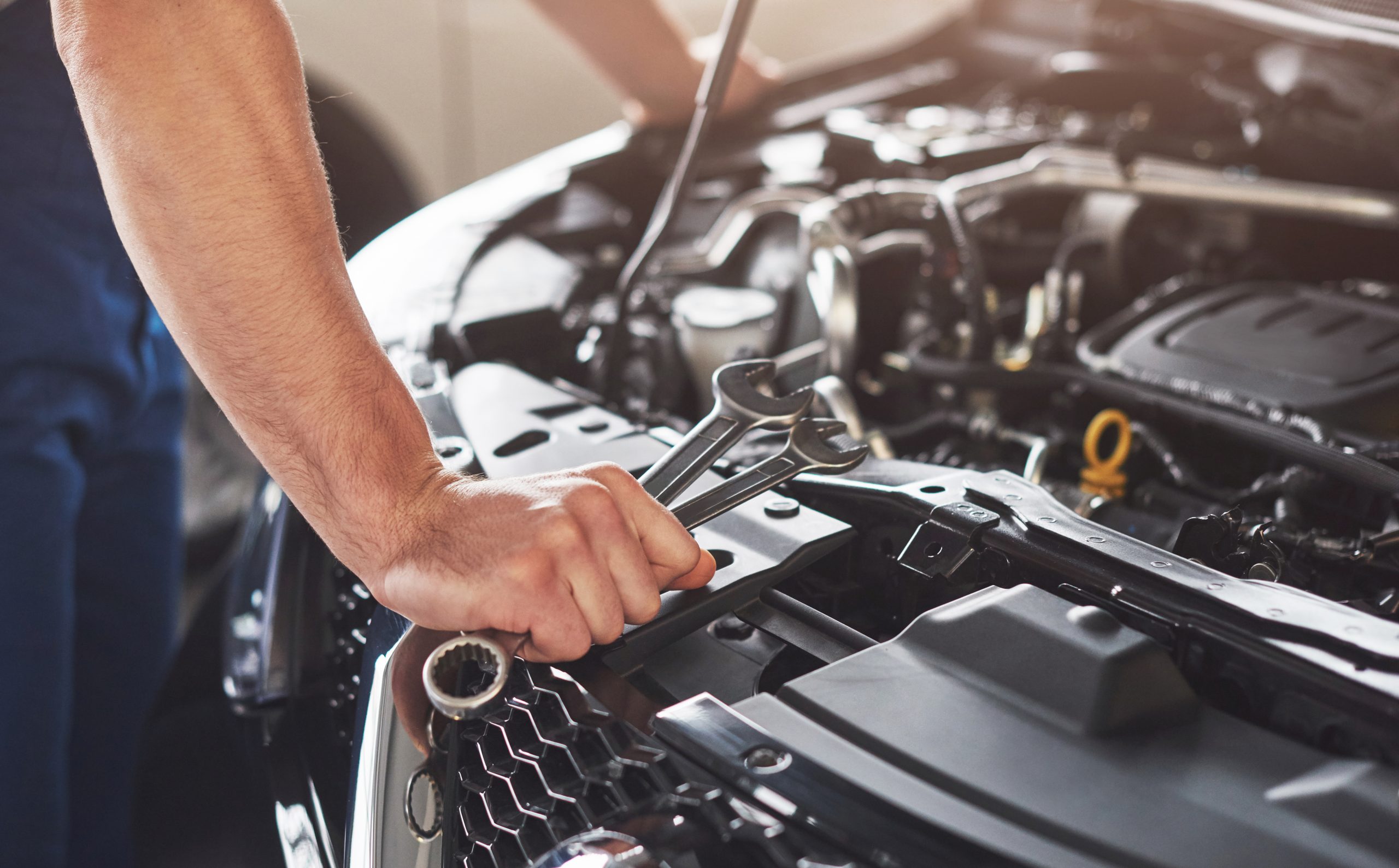 Picture showing muscular car service worker repairing vehicle