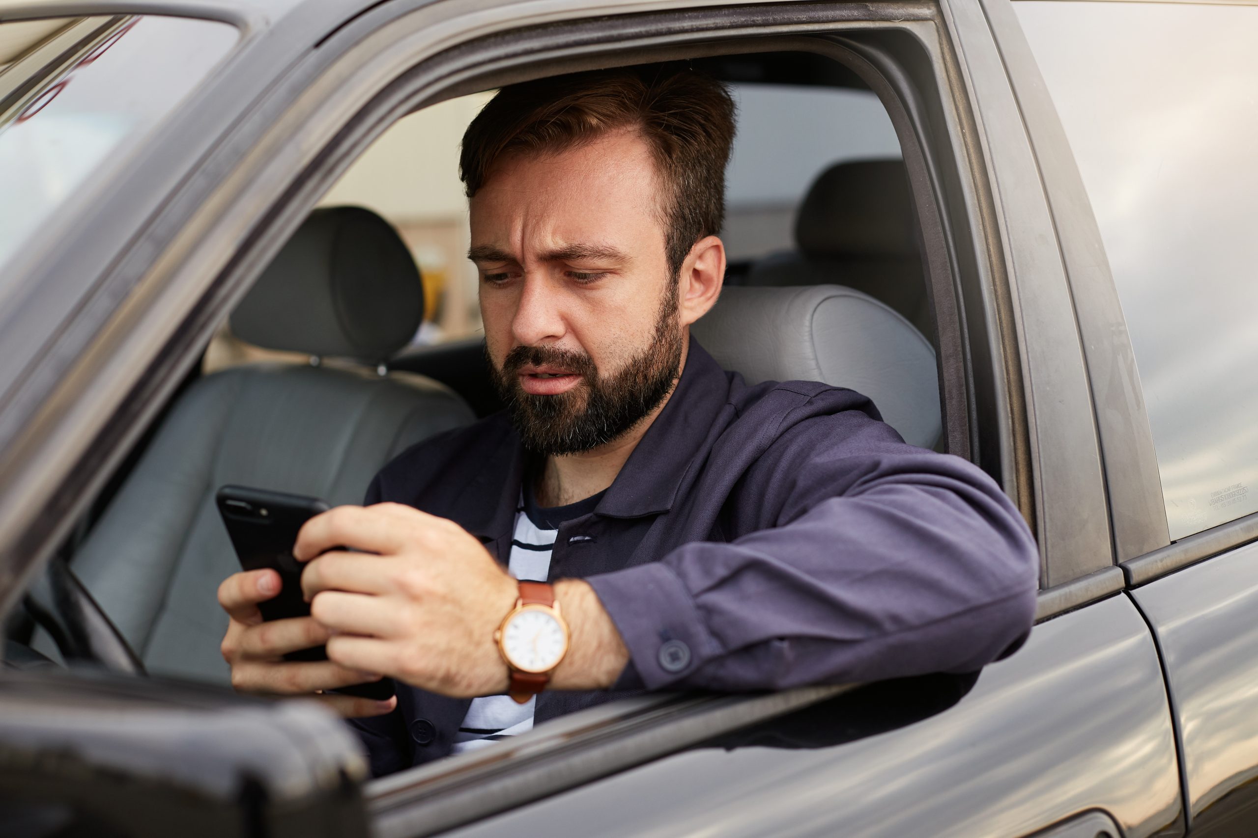Portrait of frowning dosconected bearded man in a blue jacket an