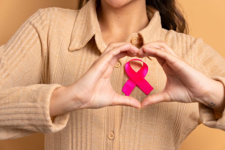 hands showing pink ribbon