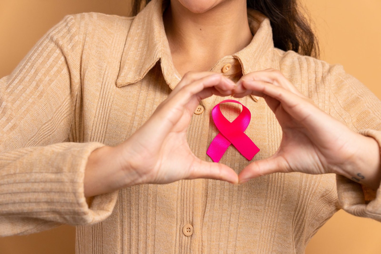 hands showing pink ribbon