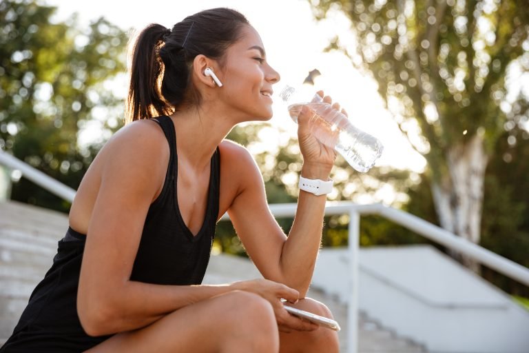 Portrait of a smiling fitness girl in earphones