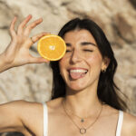 vista-frontal-mulher-feliz-segurando-laranja