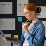 Web designer feminina no escritório com laptop freepik