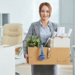 smiling-asian-woman-business-suit-standing-office-with-belongings-cardboard-box
