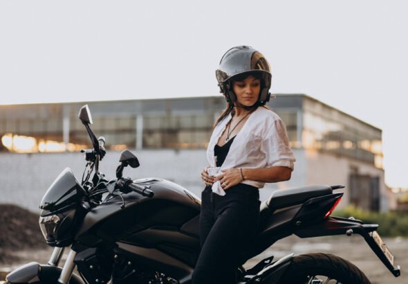 Young sexy female motorcyclist on bike