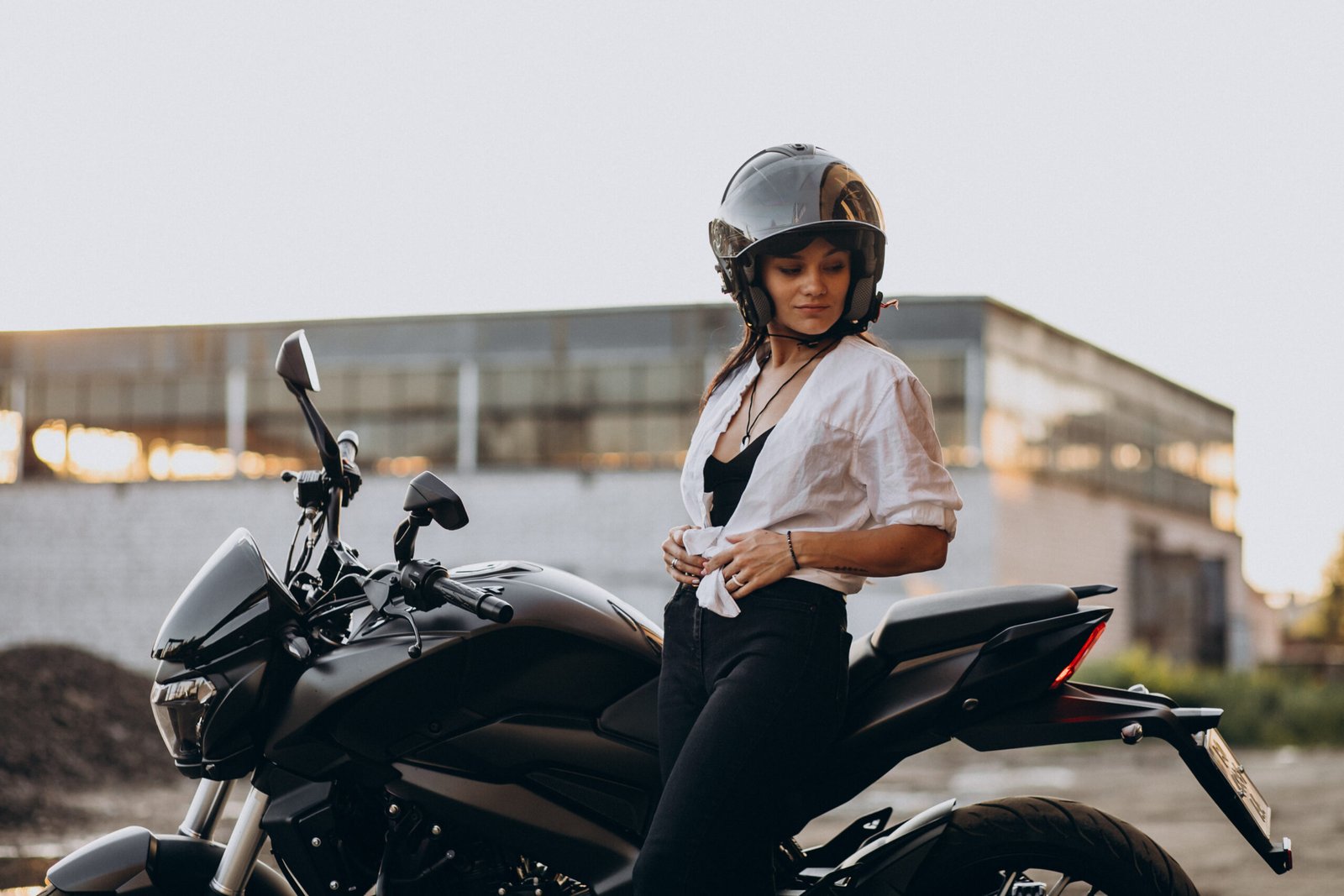 Young sexy female motorcyclist on bike